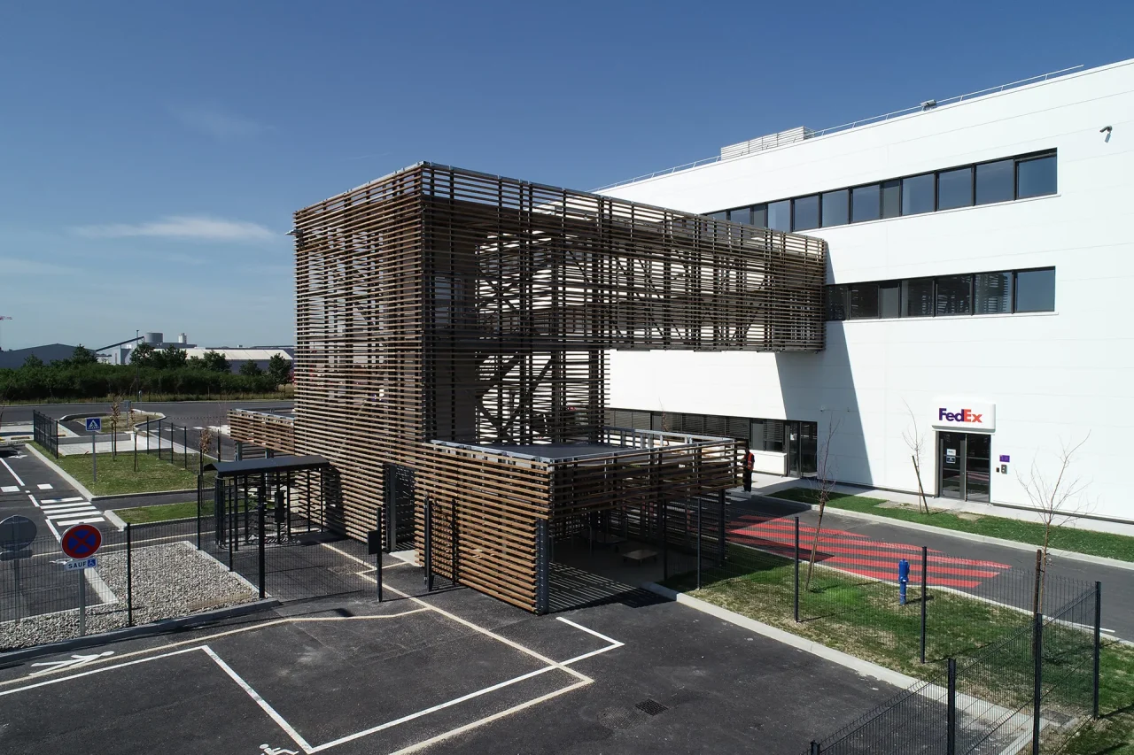 Façade moderne du bâtiment logistique avec panneaux gris et habillage bois