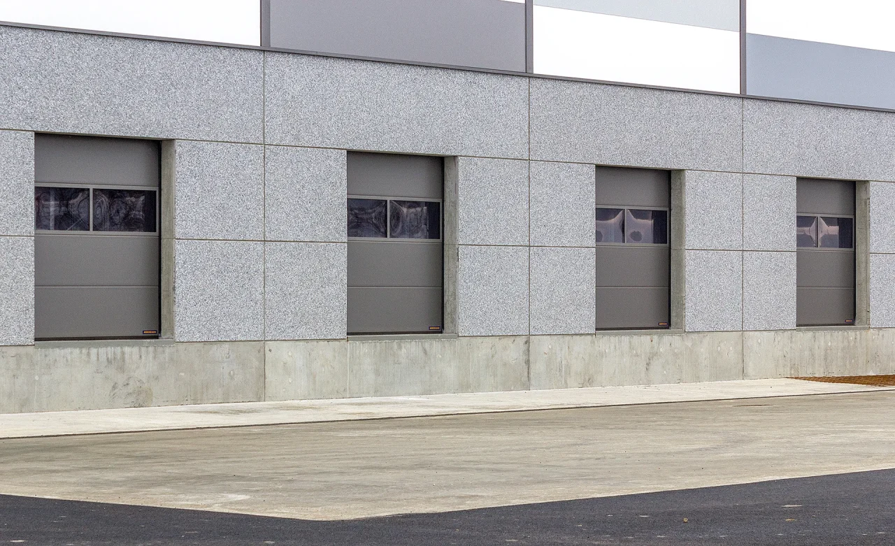Détail entrepôt logistique Muret avec portes sectionnelles et façade béton