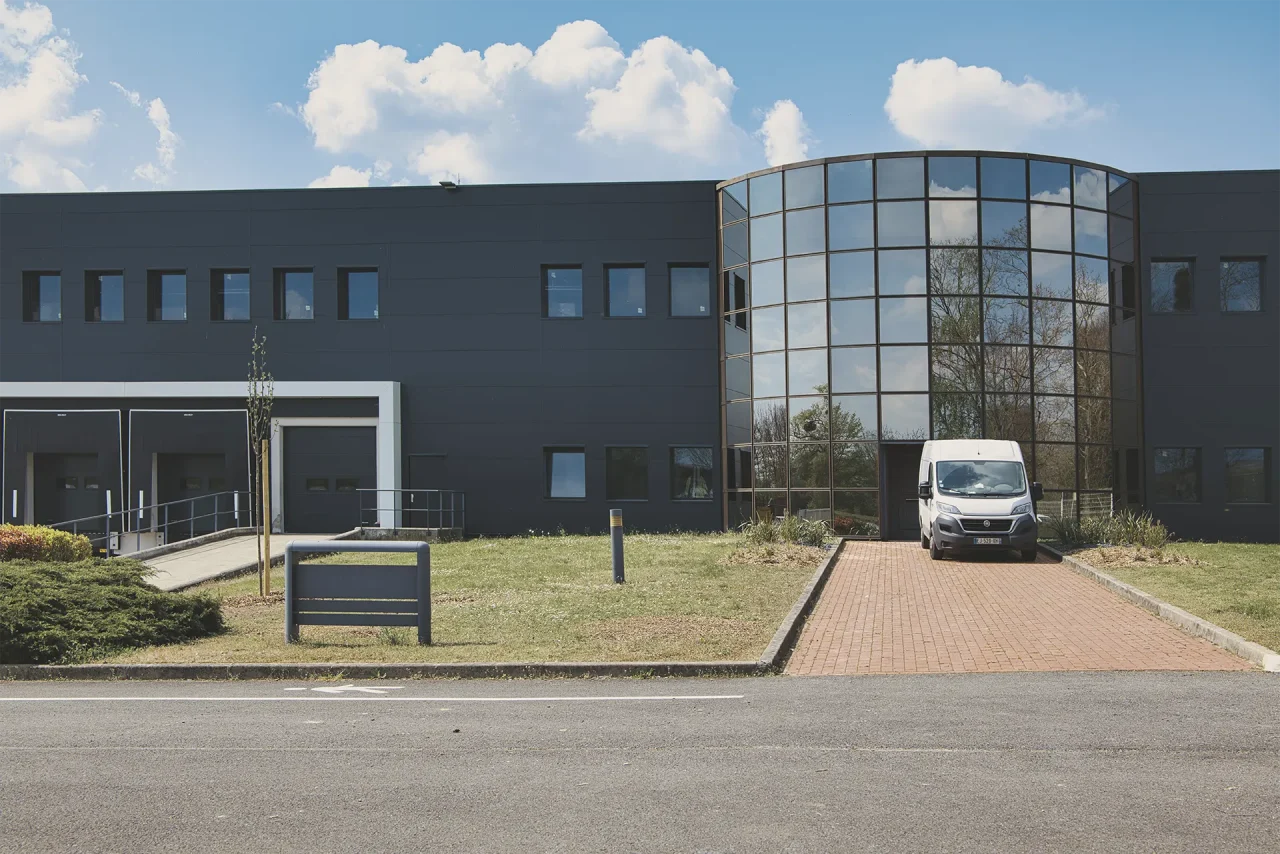 Entrée bureaux plateforme logistique Saint-Ouen-l’Aumône avec façade vitrée et accès véhicules