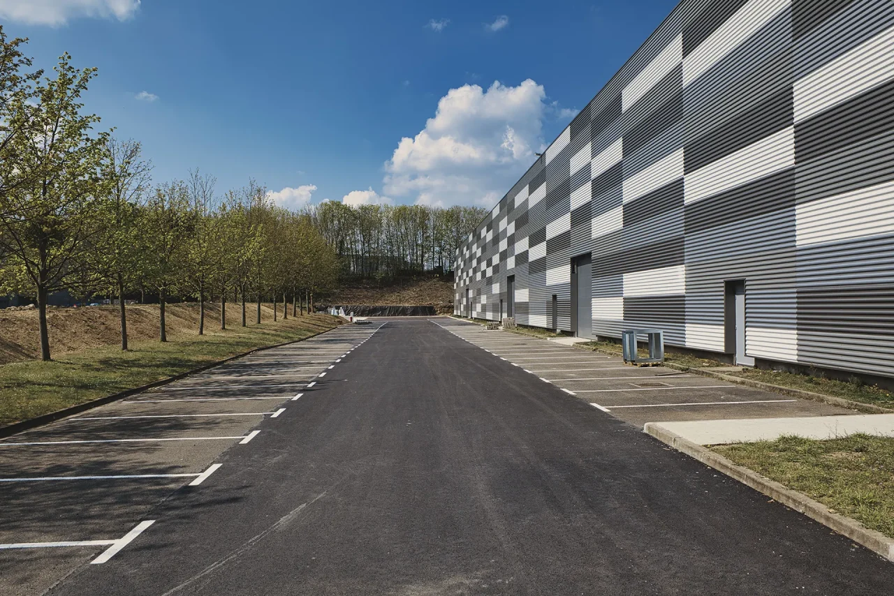 Voirie interne plateforme logistique Saint-Ouen-l’Aumône avec façade bardage métallique et stationnements