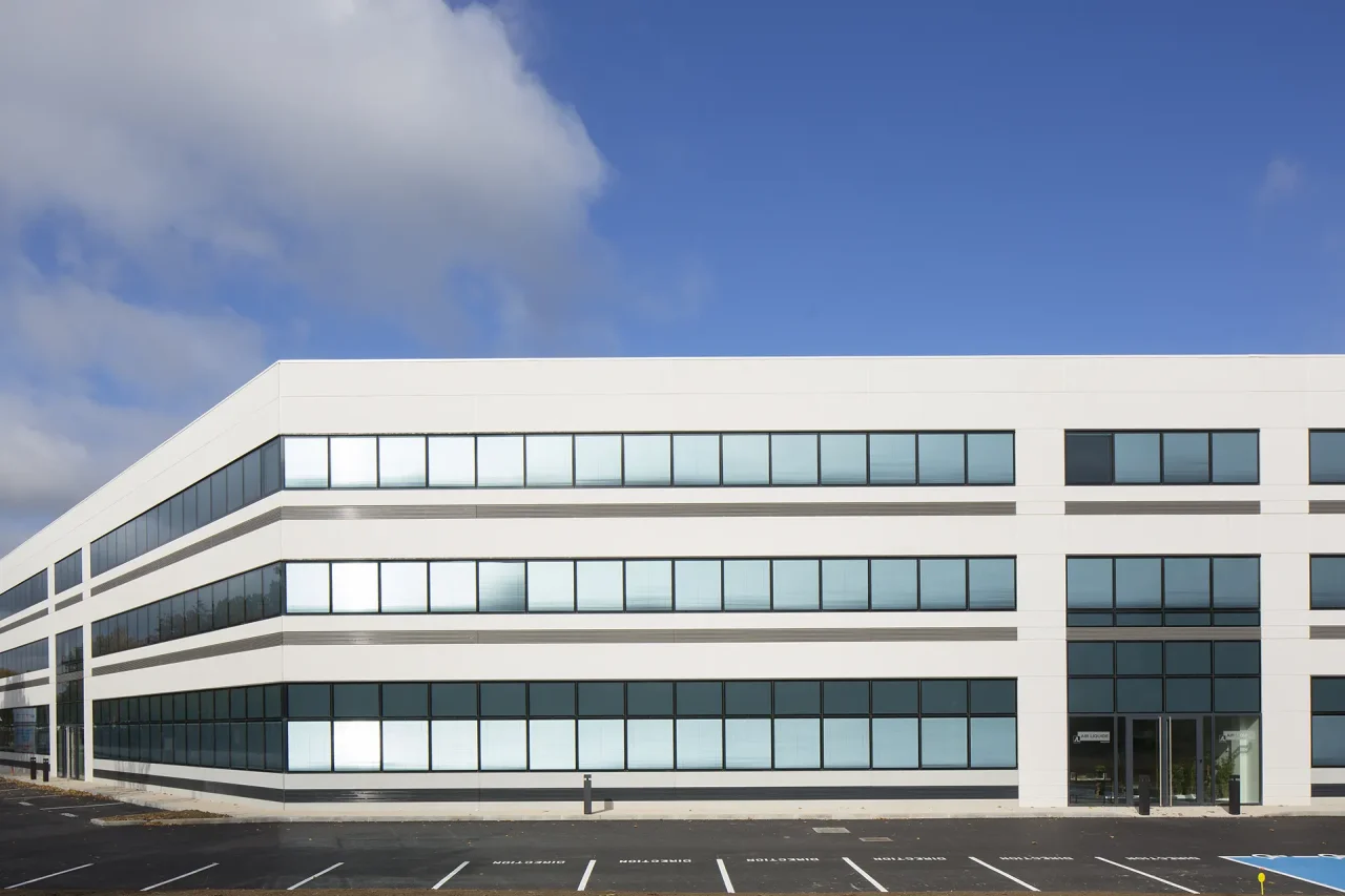 facade immeuble bureaux hqe beton blanc et vitrages continus