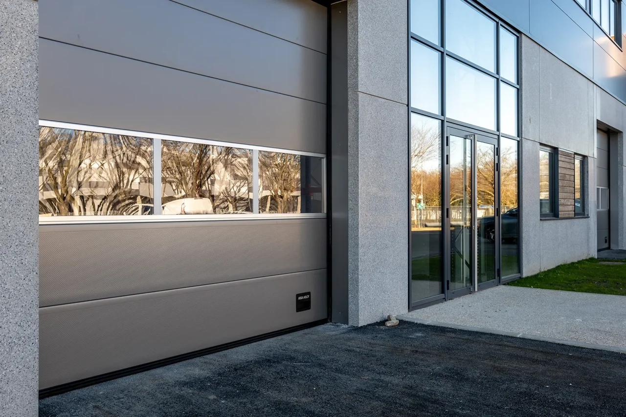 porte sectionnelle et entree bureaux batiment activites cergy horloge acces mixte logistique et tertiaire
