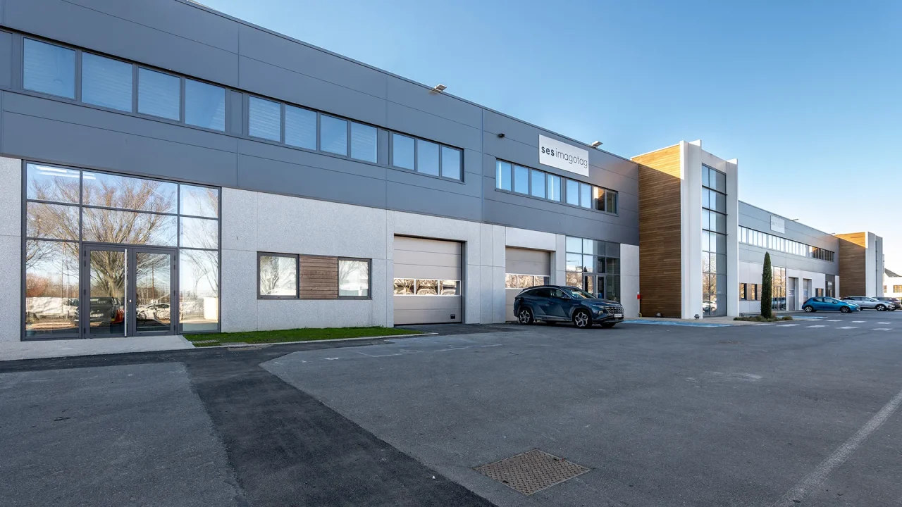 batiment activites cergy horloge facade avec portes sectionnelles acces vehicules et zones de manoeuvre
