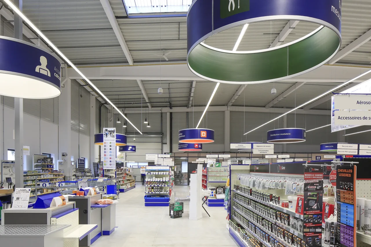 Intérieur magasin professionnel avec rayonnages et éclairage LED dans bâtiment d’activités à Saint-Ouen-l’Aumône