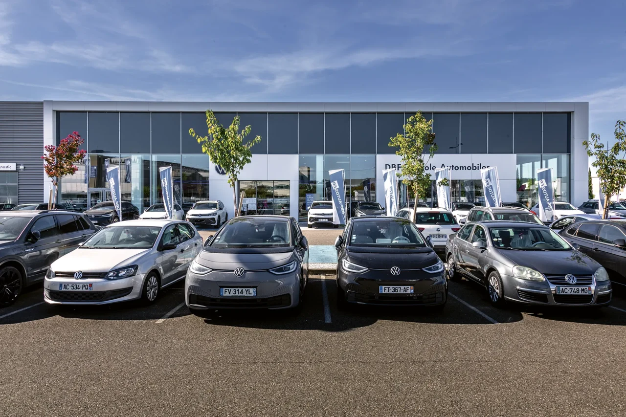 Façade vitrée de concession automobile Volkswagen avec parking clients dans parc d’activités à Toulouse route d’Espagne