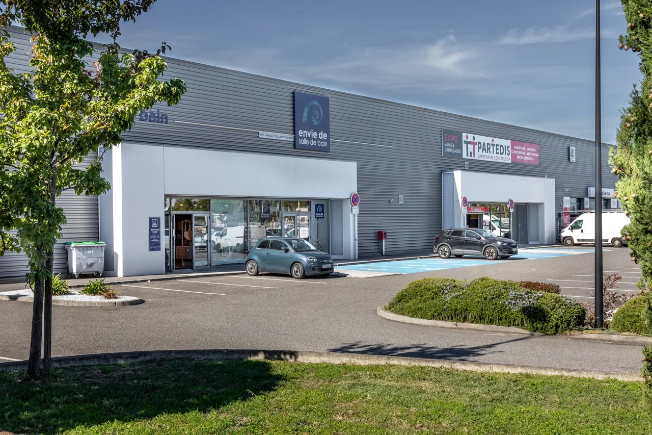 Entrées des cellules commerciales avec enseignes Envie de salle de bain et Partedis dans parc d’activités à Toulouse route d’Espagne
