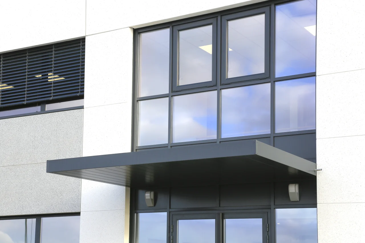 Détail entrée bâtiment industriel Lisi Aerospace Châteauroux façade vitrée et auvent
