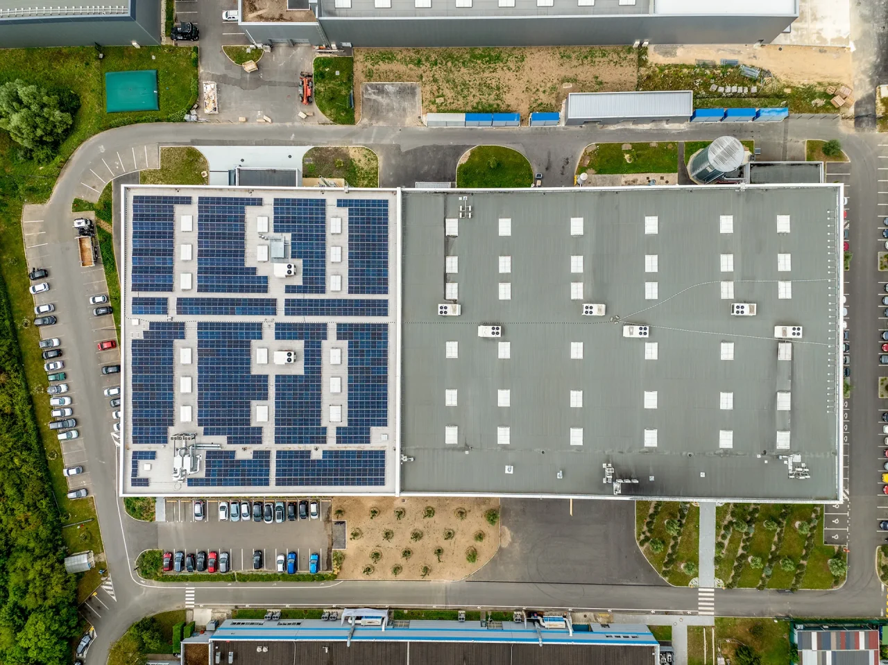 Vue aérienne zénithale du bâtiment industriel avec panneaux photovoltaïques LISI Aerospace à Saint-Ouen-l’Aumône