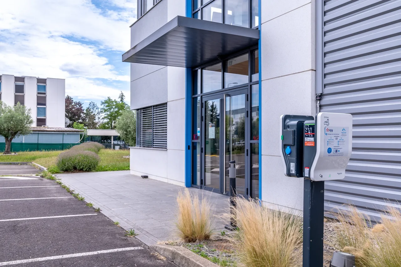 Entrée des bureaux avec borne de recharge électrique du site industriel LISI Aerospace à Saint-Ouen-l’Aumône