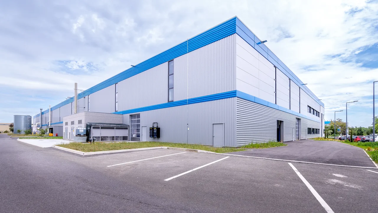 Façade industrielle du bâtiment LISI Aerospace avec accès techniques à Saint-Ouen-l’Aumône