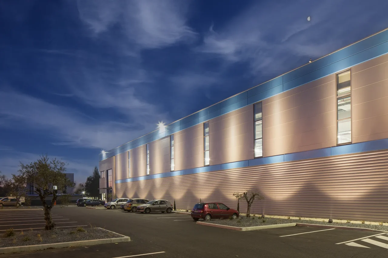 Façade éclairée de nuit de l’usine LISI Aerospace à Saint-Ouen-l’Aumône