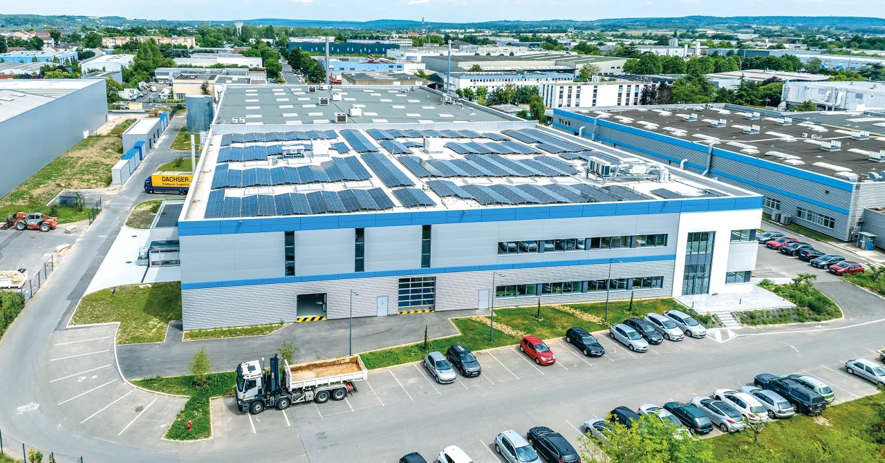 Vue aérienne rapprochée du site industriel LISI Aerospace à Saint-Ouen-l’Aumône mettant en évidence l’organisation des flux, les accès poids lourds, les stationnements et les équipements en toiture.