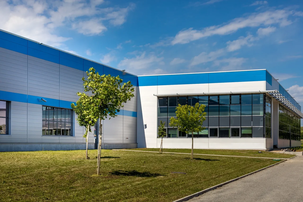 Bâtiment industriel avec façade vitrée et espaces verts sur le site LISI Aerospace à Villefranche-de-Rouergue