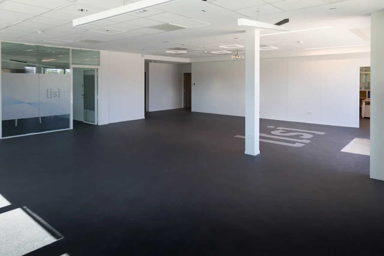Espace de bureaux open space avec cloisons vitrées dans bâtiment industriel à Villefranche-de-Rouergue