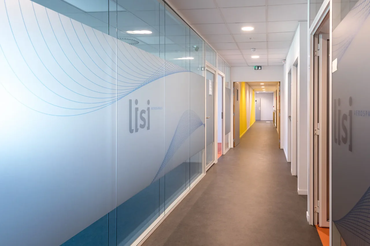 Couloir de bureaux avec vitrages sérigraphiés LISI Aerospace et aménagement tertiaire moderne