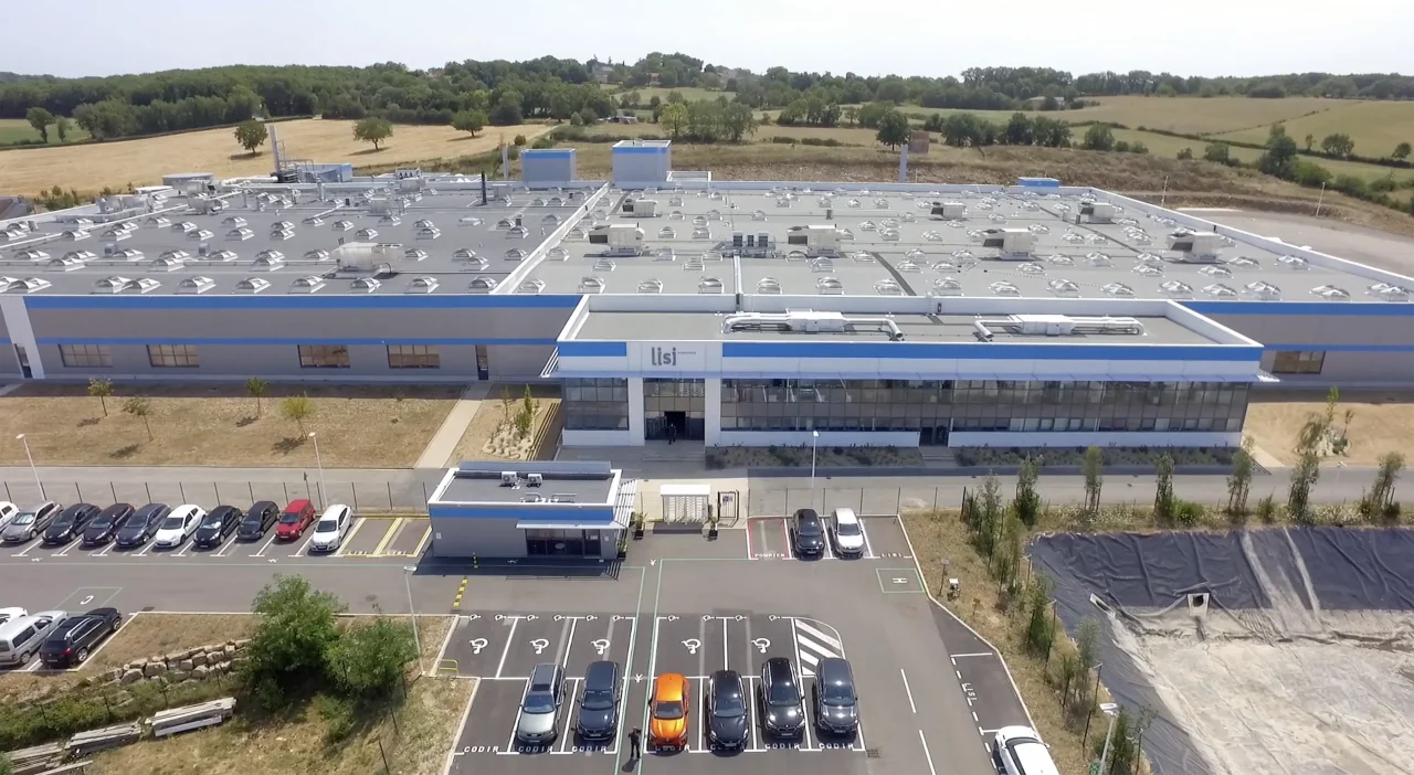 Vue aérienne globale du site LISI Aerospace avec parking, accès sécurisé et bâtiments industriels en exploitation