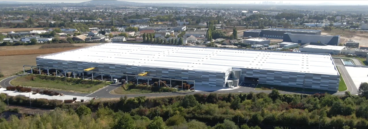 Vue aérienne de la plateforme logistique KDI avec zones de stockage extérieur et quais de chargement à Neuville-sur-Oise