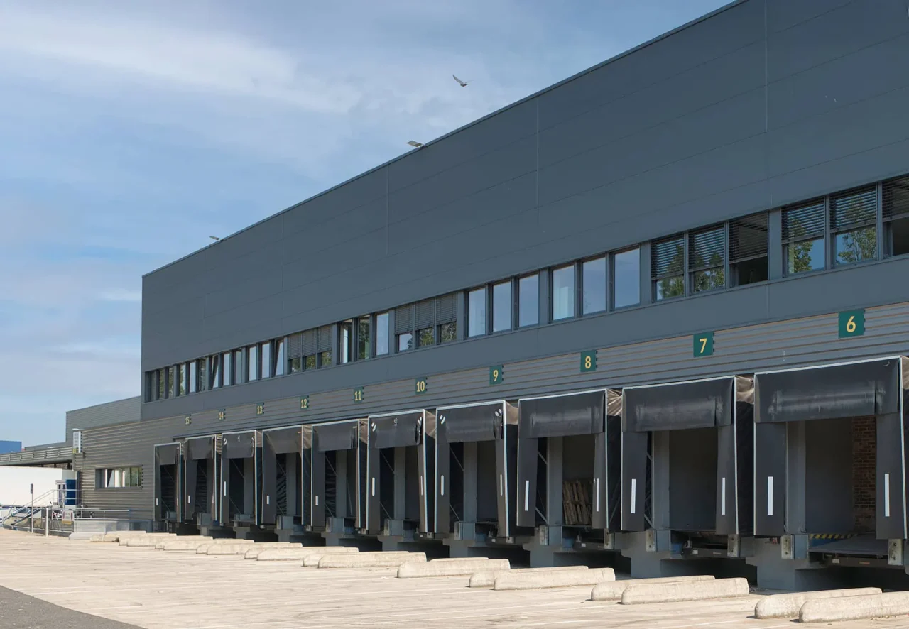 Plateforme logistique à façade gris anthracite, portes à quai équipées de sas d’étanchéité