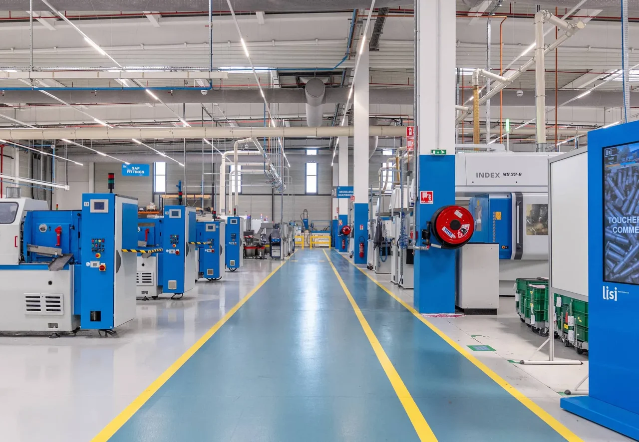 Intérieur d’une unité de production : allée centrale bleue entre deux rangées de machines
